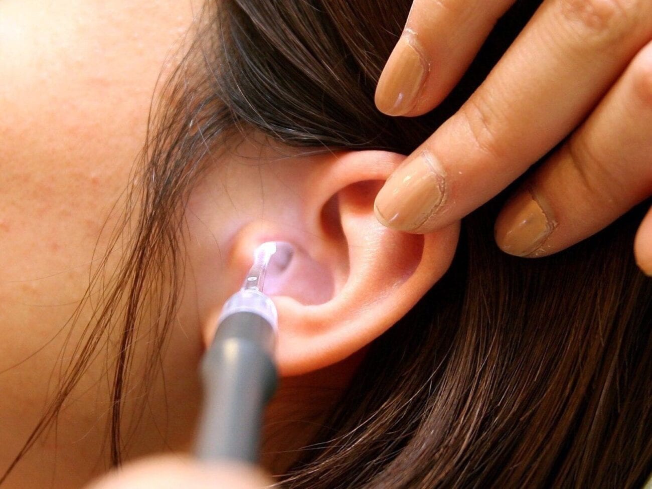 Scope looking into woman's ear for ear wax treatment
